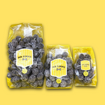 Three packages of Mr Simms sour sweets on a yellow background