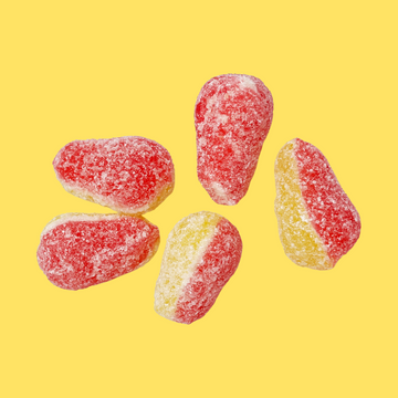 Five sugar-coated gummy candies in red and yellow-orange colors arranged on a solid yellow background.