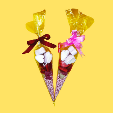 Valentines cones. Two candy cones with marshmallows and colorful bows on a yellow background