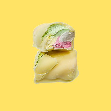 White Chocolate covered marshmallows with green and pink filling on a yellow background